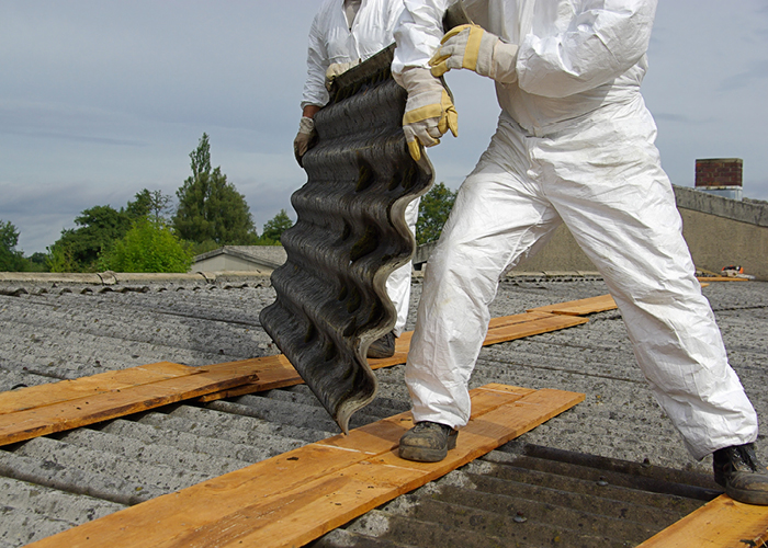 Two men removing asbestos roofing tiles